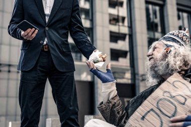 Umutsuz açlıktan ölen yaşlı soğuk zeminde oturma ve yemek için yalvarıyor adam