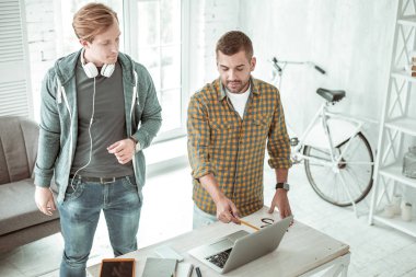 Dizüstü bilgisayar ekranında işaret eden güzel yakışıklı adam