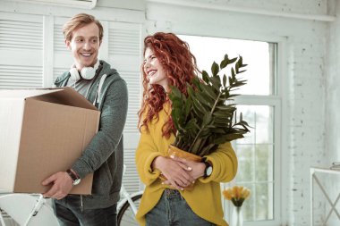 Bir bitki ile duran güzel kızıl saçlı kadın