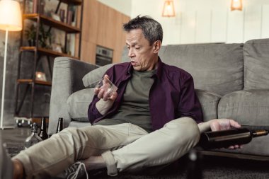 Şaşırmış sarhoş yaşlı adam anlaşılmaz bir şekilde boş cam üzerinde seyir