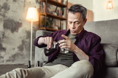 Boş kadehle sarhoş adam dökülen karanlık alkol konsantre