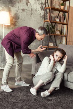 Sarhoş ve deli olurken korkmuş karısına bağırmaya gri saçlı yaşlı adam