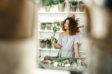 Onun faaliyet zevk çizgili üniforması genç kıvırcık çiçekçi