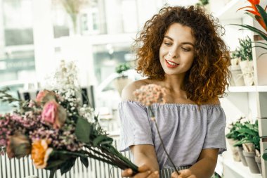 Kıvırcık çiçekçi güzel pembe çiçeklere bakarken heyecanlı hissediyorum