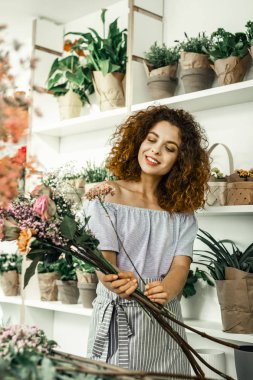 Onları elinde tutan güzel çiçekler bakarak ince çiçekçi