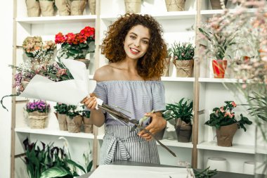 Güzel güzel buket gösterilen süre gülümseyen neşeli ışınlama çiçekçi