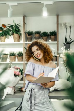 İnce çekici Çiçekçi Çiçek Dükkanı ayakta ve ona müşteri arıyor