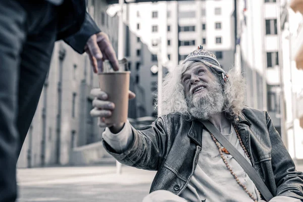 Nödställda långhåriga människa som är stackars hemlösa och samla pengar — Stockfoto