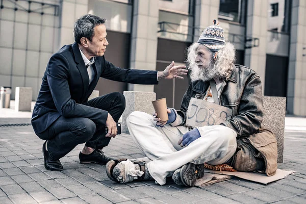 Helpful caring man in costume putting hand on shoulder of dirty homeless — Stock Photo, Image