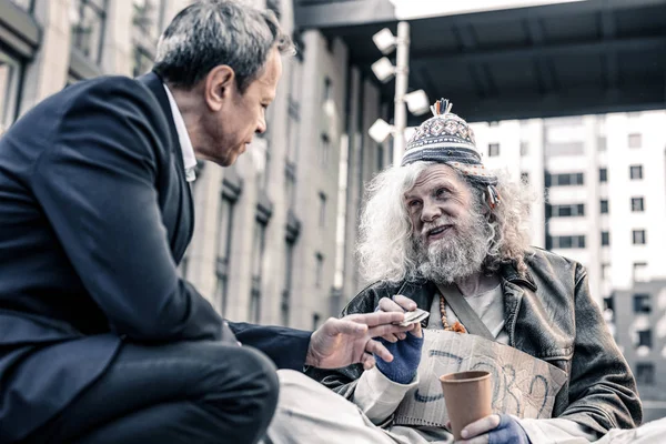 Špinavé mizerný bezdomovec s dolarovou bankovku z rukou hodný člověk — Stock fotografie