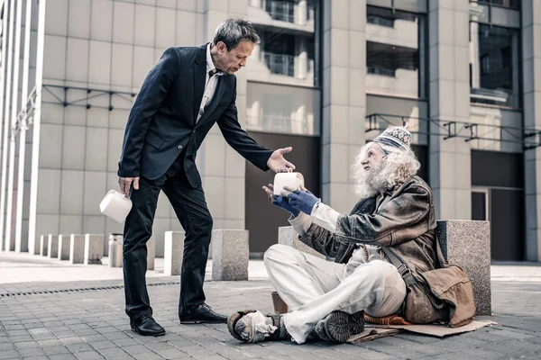 Amable hombre de negocios sincero de pelo corto compartiendo caja con comida —  Fotos de Stock