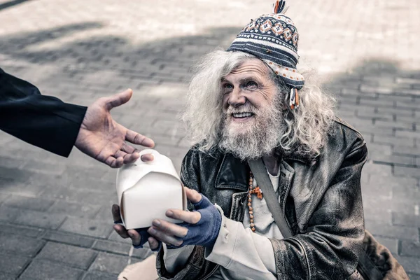 Kirli gri saçlı kıdemli yırtık elbise giyiyor ve gıda alma evsiz — Stok fotoğraf