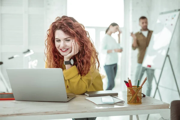 Blij intelligente jonge vrouw houdt haar Wang — Stockfoto