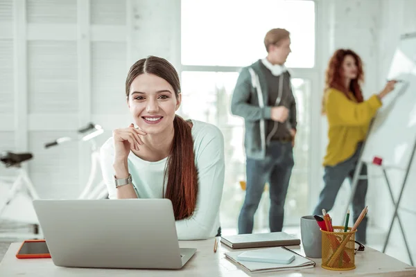 Mujer alegre positivo sentado delante de la computadora portátil — Foto de Stock