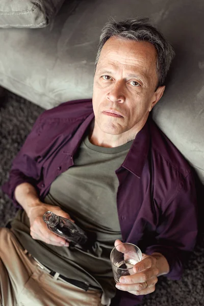 Desesperado hombre de pelo gris apoyado en el sofá y estar en un estado de ánimo horrible —  Fotos de Stock