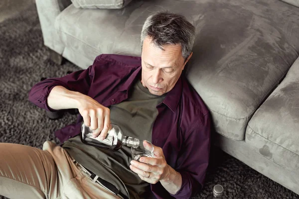 Aufmerksamer, alkoholisierter, kurzhaariger Mann schüttet frische Portion Alkohol aus — Stockfoto