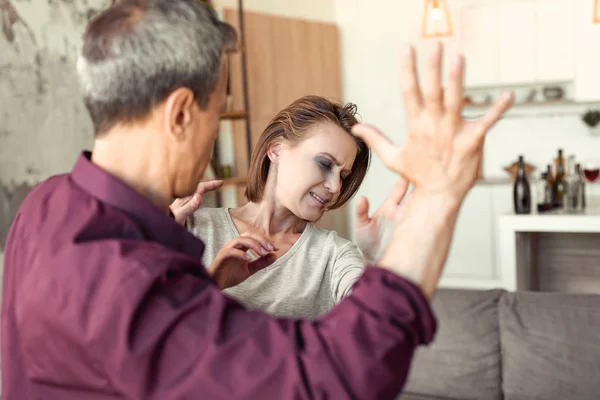 Angry man being put of control and threating his scared helpless wife — Stock Photo, Image