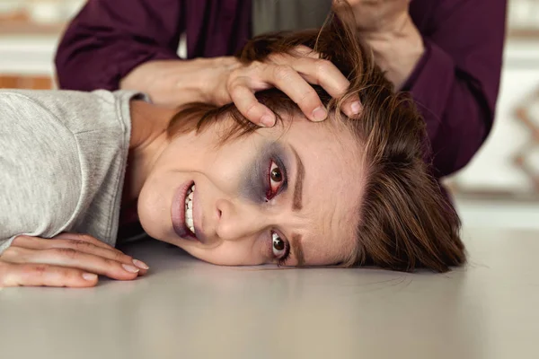 Desperate woman with bruised eye praying for life — Stock Photo, Image