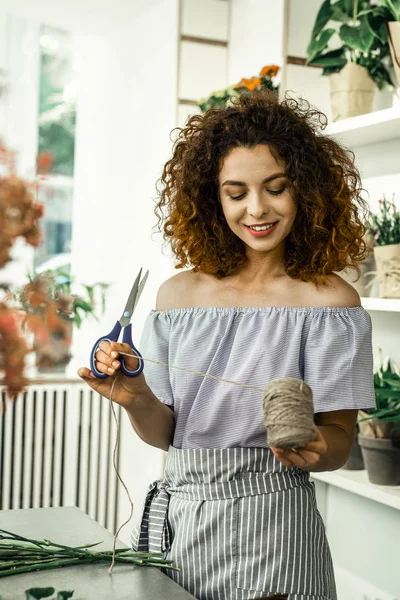 Mujer rizada pelirroja trabajando en floristería sintiéndose alegre y emocionada — Foto de Stock