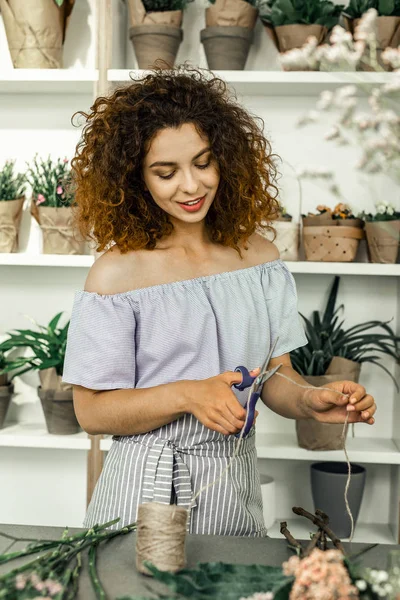 Curly red-haired florist feeling joyful and busy while making ikebana — Stock Photo, Image