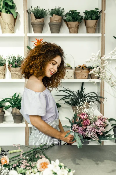 Woman looking at amazing bouquet while working in flower shop — Stock Photo, Image