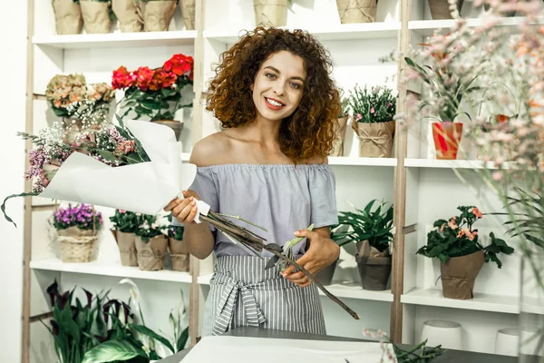 Alegre florista radiante sonriendo mientras muestra bonito ramo hermoso — Foto de Stock