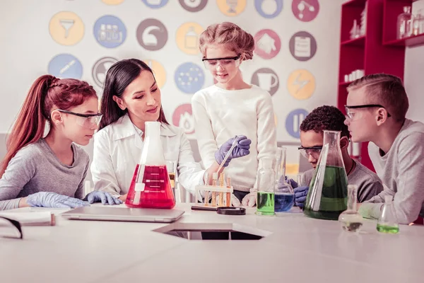 Teacher and her young group sitting by round table — Stock Photo, Image