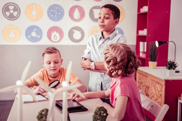 Pequeños estudiantes sentados en la sala de clase y jugando — Foto de Stock