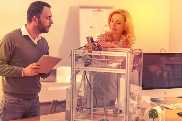 Два искренних сотрудника объединяют свои знания, чтобы заставить 3D принтер работать . — стоковое фото