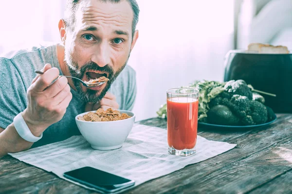 Hungriga stilig man äter frukost hemma — Stockfoto