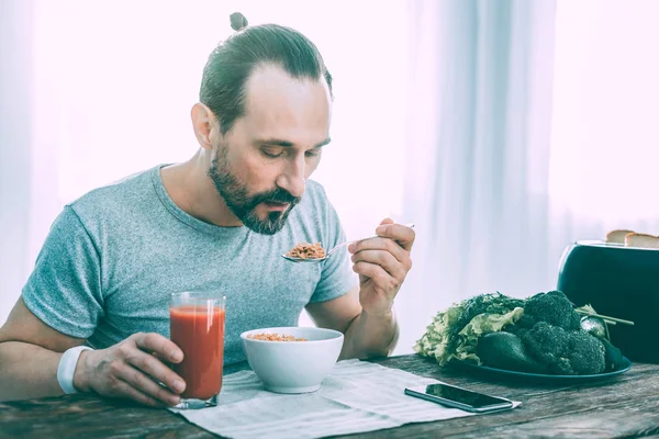 Hombre guapo agradable desayunando en la cocina — Foto de Stock