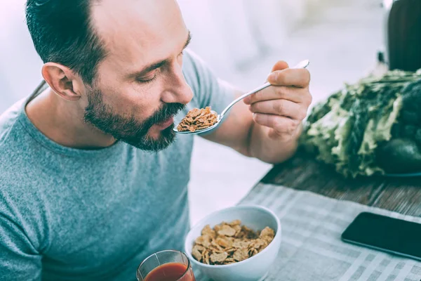 Handsome attractive man having breakfast in the kitchen — Stock Photo, Image