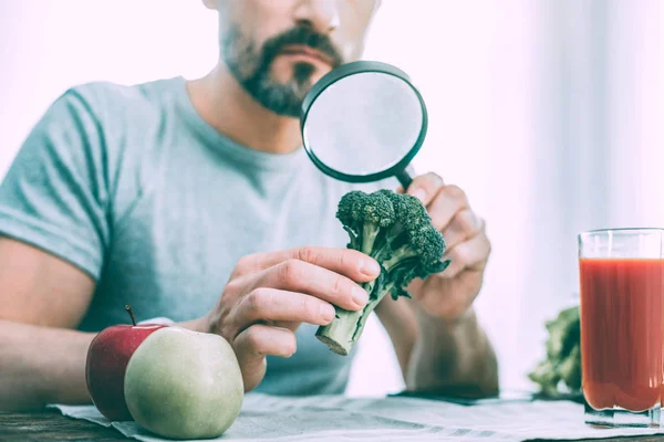 Serious calm man studying different kinds of vegetables — Stock Photo, Image