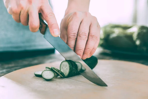 Homme motivé coupant des légumes pour préparer une salade fraîche — Photo