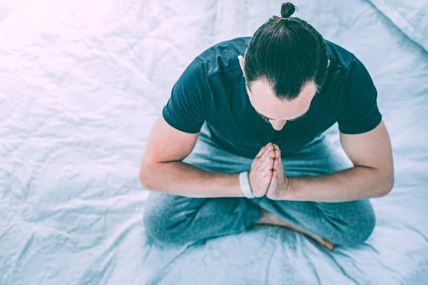 Hombre relajado y refrescante practicando yoga en una habitación —  Fotos de Stock