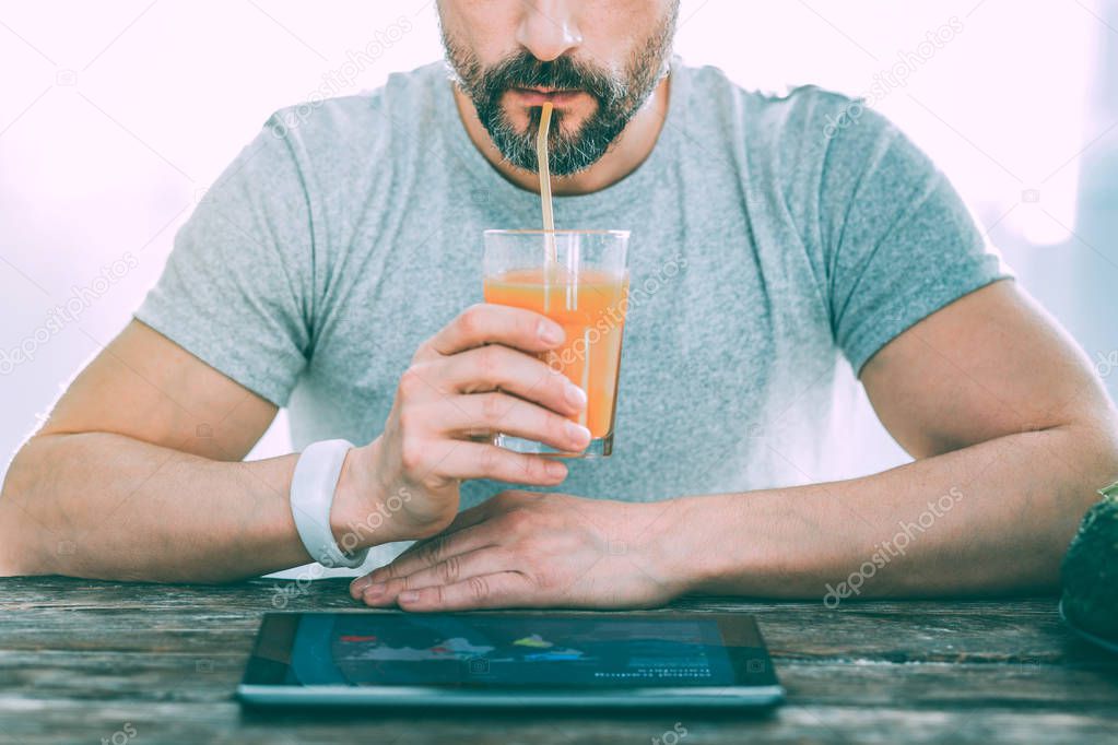 Bearded man drinking fresh cool orange juice
