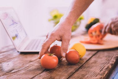 Hoş adam domates bir salata için seçme