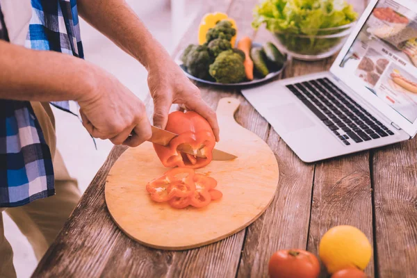 Alegre hombre agradable preparando la cena para su esposa — Foto de Stock