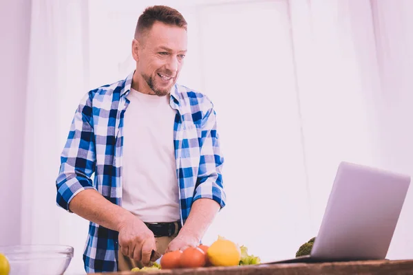 Motivated man following a recipe and cooking a tasty salad — Stock Photo, Image