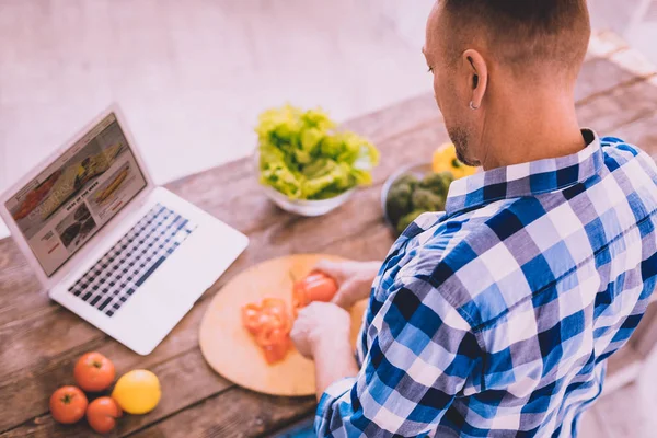 Homem moderno assistindo um vídeo como cozinhar um delicioso jantar — Fotografia de Stock