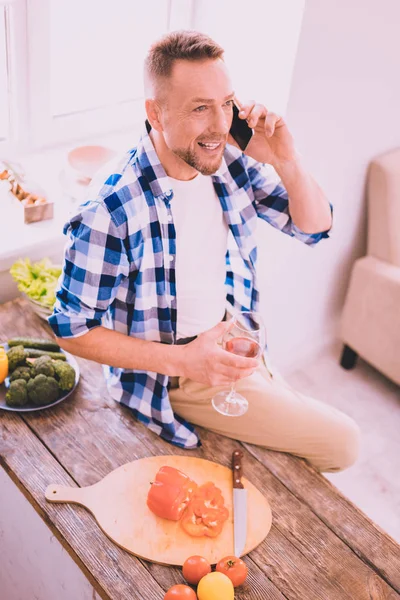 Uppsluppen mannen har en konversation med en vän på telefon — Stockfoto