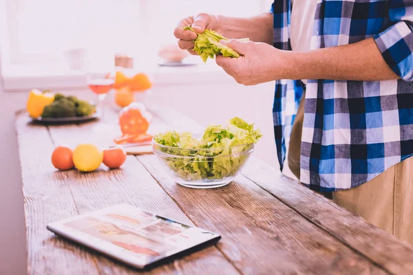 Homem inspirado preparando um prato com uma salada — Fotografia de Stock