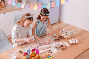 İki meşgul Kızlar bisküvi pişirme için hazırlanıyor