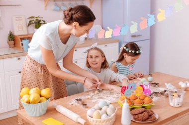 Memnun anne çocukları ile birlikte bisküvi yapıyor