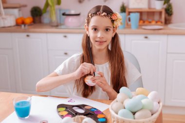 Doğruca kameraya bakarak uzun saçlı çocuk