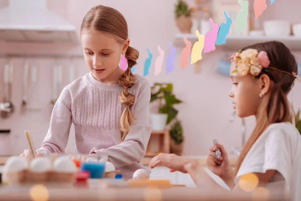 Attentive longhaired girl following example of her friend — Stock Photo, Image