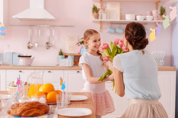 Positivo encantado garoto apresentando flores para sua mãe — Fotografia de Stock