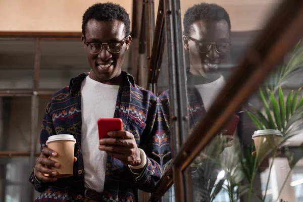 Hombre sosteniendo una taza de café agarrado con conversación de mensajes de texto — Foto de Stock