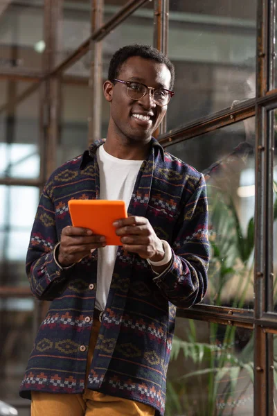 Sonriente hombre mensajes de texto con un amigo usando una tableta — Foto de Stock