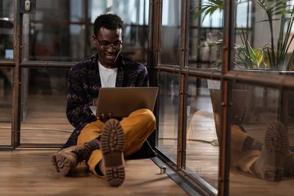 Man zittend op de vloer tijdens het werken met computer — Stockfoto